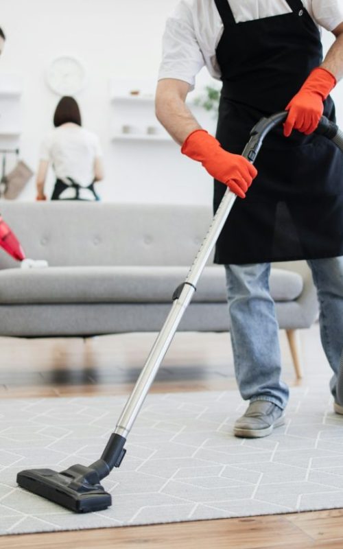 cropped-view-of-professional-cleaner-from-cleaning-service-vacuums-carpet-.jpg